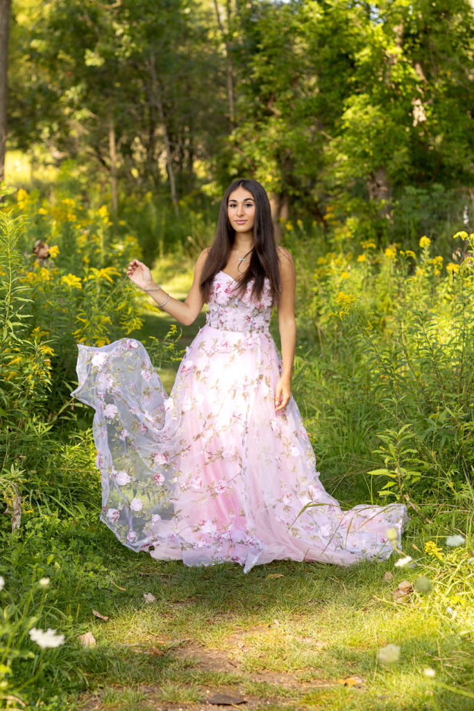 Senior in pretty pink dress in field